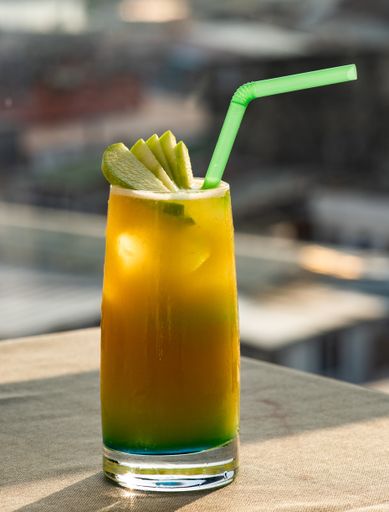 A vertical selective focus shot of a ginger ale cocktail on blurred background