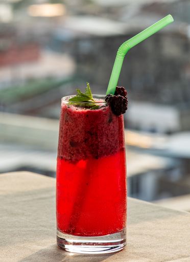 A vertical selective focus shot of a non-alcoholic drink on blurred background