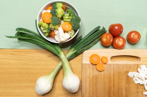 An overhead shot of a wooden board with different kinds of vegetables on it