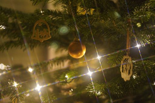 A closeup shot of a Christmas ornament with lights shining around it