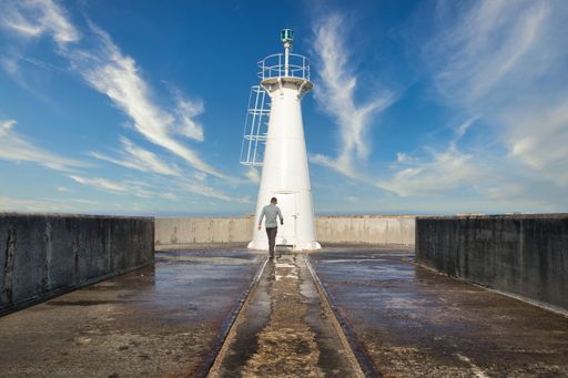 a male walking towards the lighthouse in East London, South Africa.