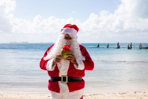 Santa Claus drinking a coconut at Isla Mujeres Mexico Beach