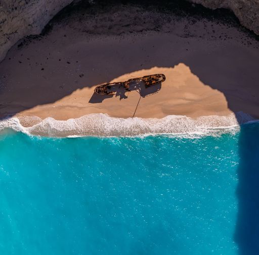 An aerial top view of a shipwreck on the shore of Volimes, Zakynthos, Greece