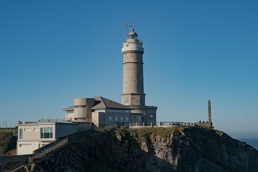 The Cabo Mayor lighthouse in Cantabria, Spain stands atop a rocky cliff