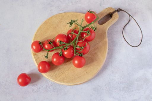 Red cherry tomatoes served on a wooden board