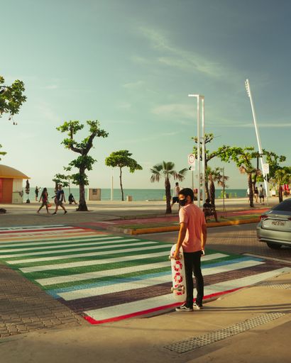 A vertical shot of a young Man crossing street near the beach in Fortaleza, Brazil