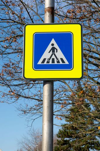 A closeup view of pedestrian crossing road sign