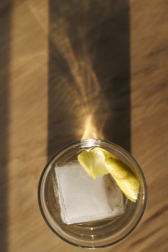A vertical shot of a tequila shot with lemon slices and ice
