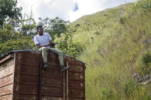 A man on an old booth with a camera on his trip through the mountains of Miranda