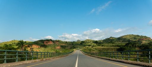 A road-bridge surrounded by hills and greenery over the Keve River in Angola