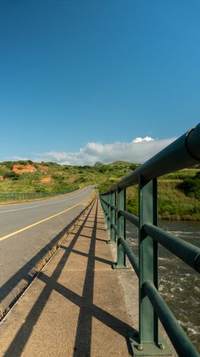 A bridge surrounded by hills and greenery over the Keve River in Angola