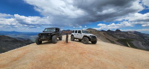 A man standing in the middle of two Jeeps in Imogene Pass near Telluride