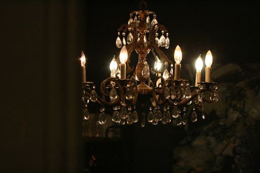 A closeup of a chandelier hanging from ceiling in a dark room