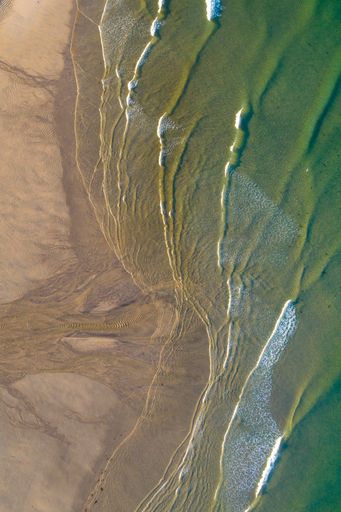 shore of a beach at daybreak aerial view with drone
