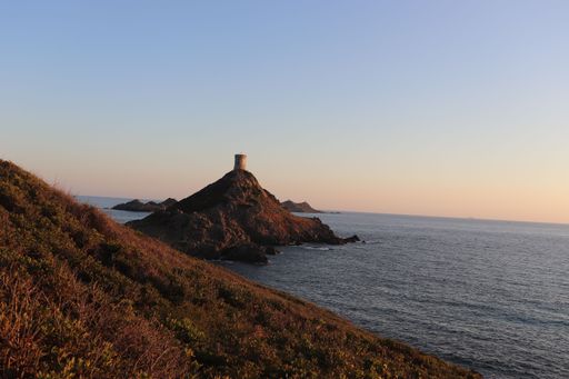 A scenic shot of the Pointe de la Parata island with the evening sun setting on the horizon