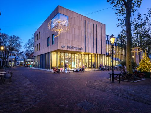 The library of Deventer during the blue hour and people with bikes in front of it, in the Netherlands