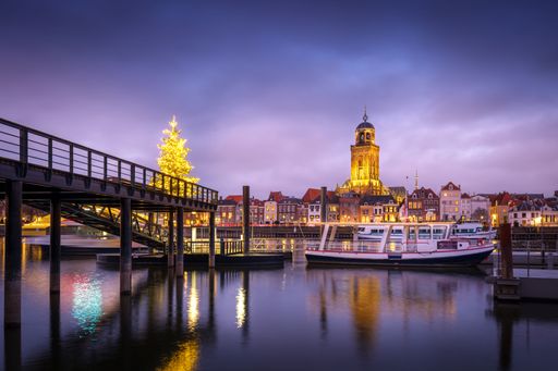 A ship near a harbor on the river IJssel in Deventer  with the St. Lebuinus Church on the background