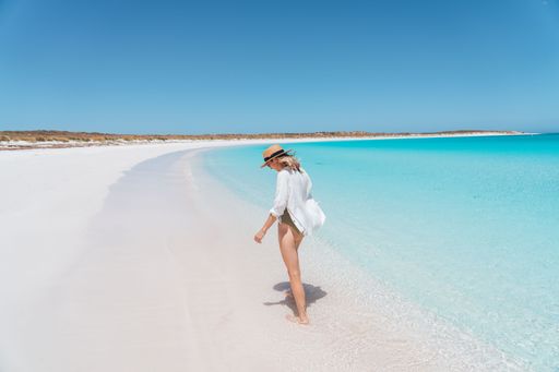 A young happy Caucasian female enjoying her vacation at the sandy beach