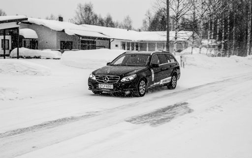 A black Mercedes-Benz car parked in the street in front of the houses on a cold snowy day, Rovaniemi, Finland
