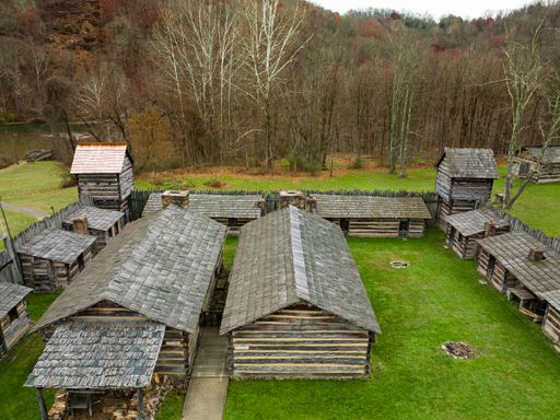 An aerial view of rural wooden houses on a green lawn
