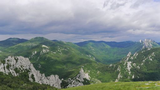 An aerial landscape view of Mountain range of Velebit, Croatia with sunset cloudy sky