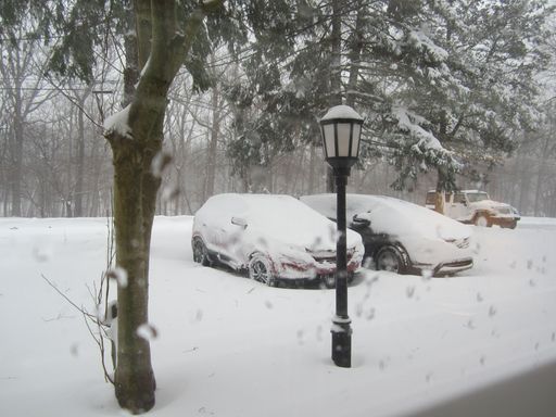 An image of two vehicles parked next to a lamppost on a snowy day