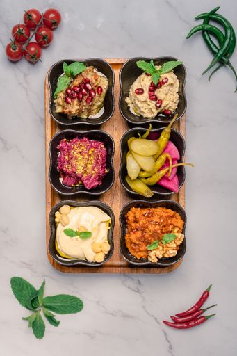 A top view of a variety of food items and condiments, arranged on a white tray