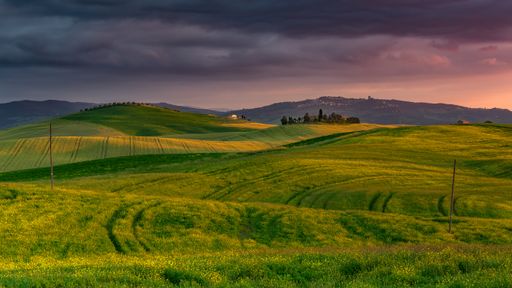 A beautiful scenery of a field surrounded by hills in the countryside