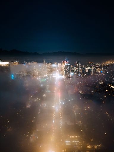 4k drone shot of fog covering Vancouver city at night