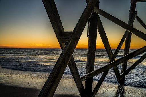 A beautiful orange sunset over a wooden pier in Myrtle Beach, South Carolina