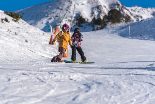 Pas de la Casa, Andorra: January 3, 2021: Mother with her Child skiing in the Pyrenees at the Grandvalira ski resort in Andorra in time of Covid19