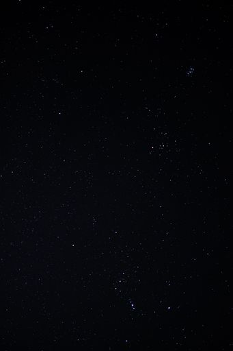 A low angle vertical shot of a sky full of bright stars and galactic