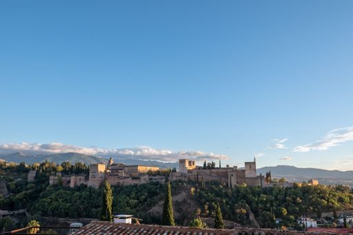 Aerial view of the Alhambra Palace in Granada, Spain with snow-capped Sierra Nevada mountains in the background..
