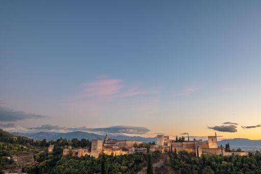 Aerial view of the Alhambra Palace in Granada, Spain with snow-capped Sierra Nevada mountains in the background..
