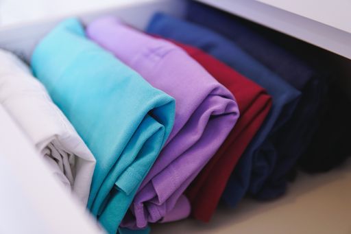 A lot of different folded clothes perfectly arranged in a closet - Marie Kondo Konmari method concept