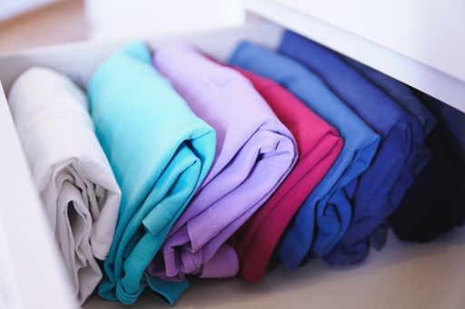 A lot of different folded clothes perfectly arranged in a closet - Marie Kondo Konmari method concept