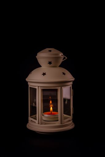 A vertical shot of a metal star cutout lantern isolated on black background