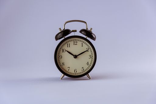 A closeup of a vintage alarm clock isolated on blurred white background