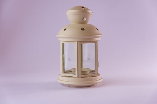 A vertical shot of a metal star cutout lantern isolated on purple background