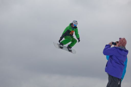 A snowboarder jumping high through the air at the Wisp Ski Resort in Deep Creek Lake Maryland