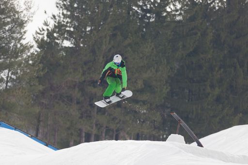 A snowboarder jumping high through the air at the Wisp Ski Resort in Deep Creek Lake Maryland