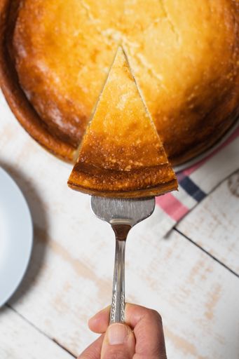 A top view of a person taking a piece of delicious homemade pie on a tray on the table