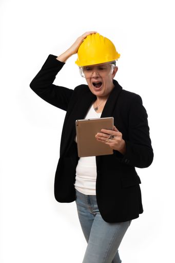 An engineer woman angrily looking at the tablet on white background