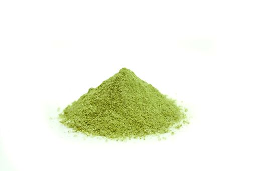 Piled up green matcha powder in isolated white background. Front view.