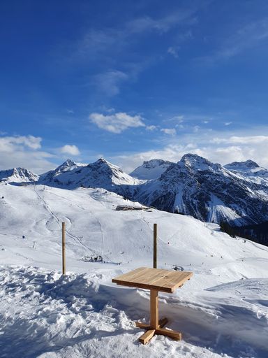 A beautiful shot of a wooden table in high snowy mountains