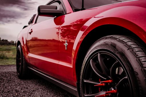 A red Ford Mustang on Old Country Road
