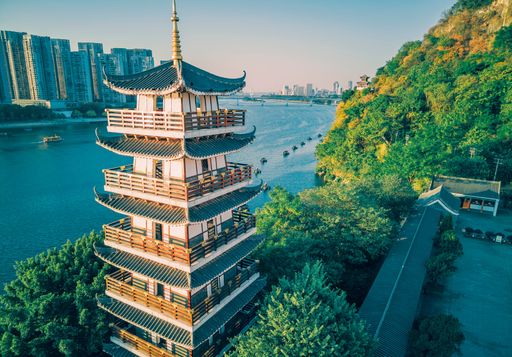 The setting sun shines on a tower by the river in Liuzhou, Guangxi, China, Asia