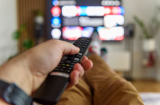 A closeup view of a remote control held on a male hand