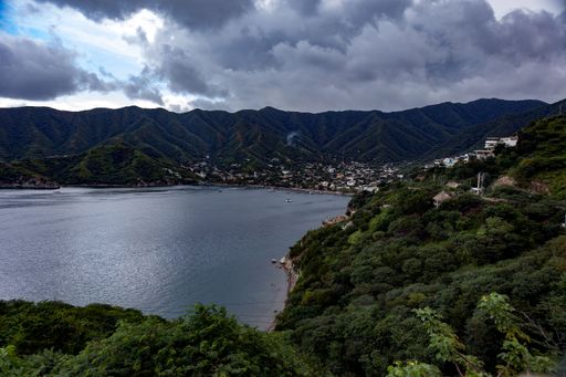 A tranquil lake surrounded by lush forested hills in the idyllic town of Taganga