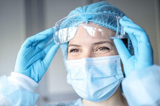 A portrait of a female medical doctor wearing a face mask and cap for patients surgery work